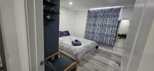 a small bedroom with a bed and a window at Entire guest basement suite in Cochrane, AB in Cochrane