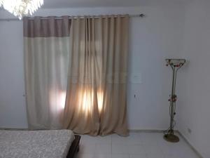 a bedroom with a bed and a window with curtains at Marina tabarka in Tabarka
