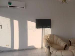 a living room with a chair and a television at Marina tabarka in Tabarka