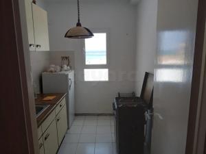 a small kitchen with a refrigerator and a window at Marina tabarka in Tabarka
