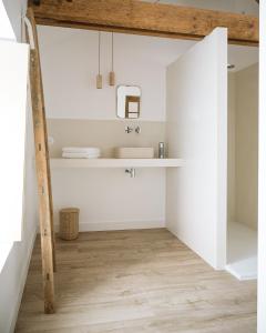 a bathroom with white walls and a sink at L'Annexe Singulière in Maillé