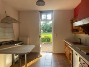 a kitchen with a counter and a door to a yard at La Raimbauderie, villa 4 étoiles, avec clim, au coeur de la nature et des vignobles in La Chapelle-Montlinard