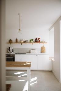 a kitchen with white cabinets and a wooden table at L'Annexe Singulière in Maillé +20 photos