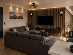a living room with a couch and a flat screen tv at Weromerie Premium Hotel and Apartment in Wormer
