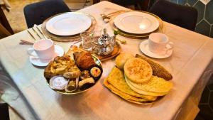 a table with a plate of breakfast foods on it at Dar Al Massir in Chefchaouen