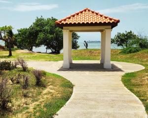a gazebo with a roof on a sidewalk at Beachfront Ocean View Loft with Beach, Pool and Parking in Portmore