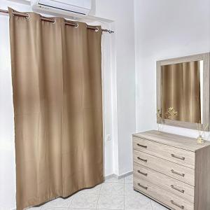 a shower curtain next to a dresser and a television at Dimitra's House in Kefalos +9 photos