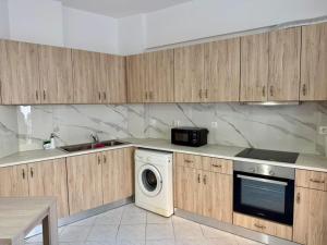 a kitchen with wooden cabinets and a washer and dryer at Dimitra's House in Kefalos