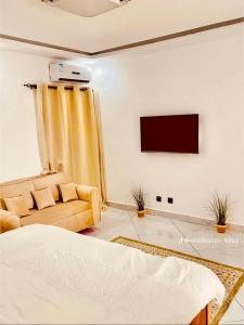 a living room with a bed and a tv at Appart lotus in Cocody