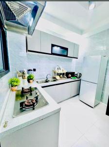 a white kitchen with a sink and a refrigerator at Appart lotus in Cocody