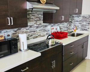 a kitchen with a sink and a stove top oven at Beachfront Ocean View Loft with Beach, Pool and Parking in Portmore