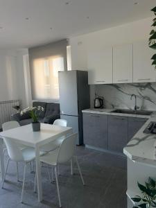 a kitchen with a white table and white chairs at My Sicily apartments in Taormina