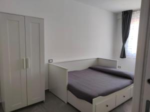 a white bedroom with a bed and a window at My Sicily apartments in Taormina
