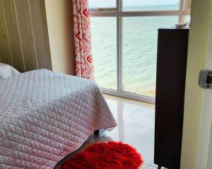 a bedroom with a bed and a window with the ocean at Beachfront Ocean View Loft with Beach, Pool and Parking in Portmore +30 photos