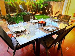 a table with glasses and a bowl of fruit on it at Bungalow with Pool & BBQ - Carabassi Beach 10' in Gran Alacant