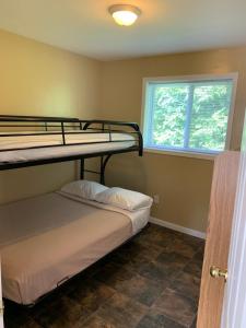 two bunk beds in a room with a window at Wu Wu's Cabins in Wasaga Beach