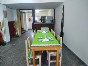 a dining room with a green table and chairs at Camino del Inca in Cachí