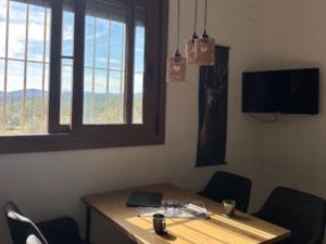 a room with a wooden table with chairs and a window at Vila Girasoles in Cálig