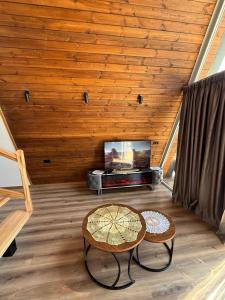 a living room with a table and a tv at Villas Çeremi in Maskollatë