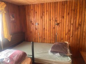 a small room with a bed in a wooden wall at Alojamiento Halcones in Concepción +3 photos