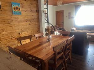 a dining room with a wooden table and chairs at Alojamiento Halcones in Concepción
