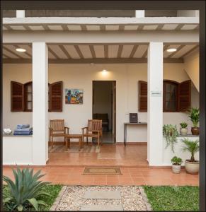 a patio with white columns and a table and chairs at Casa com piscina e área gourmet próximo à praia com quarto suíte privativo in Saquarema +5 photos