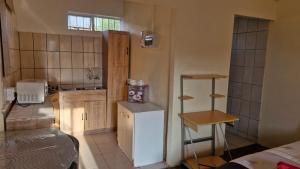 a small kitchen with a white refrigerator in a room at Self Contained Batchelor pad in Germiston