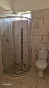 a bathroom with a shower with a toilet at Self Contained Batchelor pad in Germiston