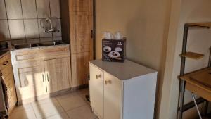 a kitchen with a box of donuts on top of a refrigerator at Self Contained Batchelor pad in Germiston +2 photos