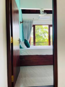 a view of a bedroom with a bed and a window at Villa Serandiva in Galle