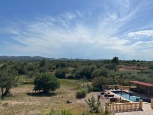 a pool in the middle of a field with trees at Vila Girasoles in Cálig