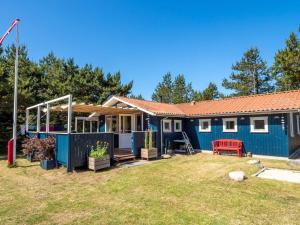 a blue house with a red bench in a yard at 6 person holiday home in Thisted in Thisted