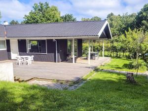 a detached house with a deck and a patio at 8 person holiday home in Melby in Melby