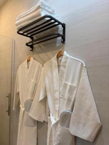a group of white shirts hanging on a rack at Malaga Rooms in Málaga +12 photos