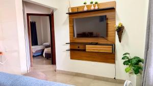 a living room with a television on a wall at Apartamento minutos do centro in Sinop +1 photo