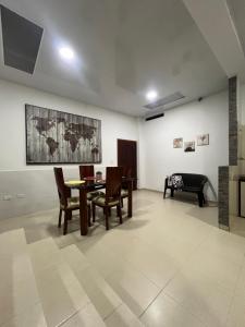 a living room with a table and chairs and a piano at Casa de Libre Independencia in Mocoa
