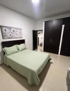 a bedroom with a large bed and black cabinets at Casa de Libre Independencia in Mocoa