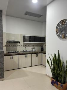 a kitchen with a large clock on the wall at Casa de Libre Independencia in Mocoa
