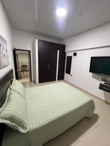 a bedroom with a bed and a flat screen tv at Casa de Libre Independencia in Mocoa +5 photos
