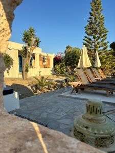 a group of chairs and umbrellas on a patio at 7Olives Emerald Boutique Apartment in Kastraki +17 photos