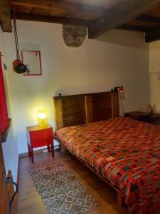 a bedroom with a bed and a table with a lamp at Casa Alex in Roure Turin