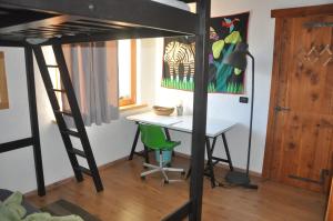 a bedroom with a desk and a loft bed at Casa Alex in Roure Turin