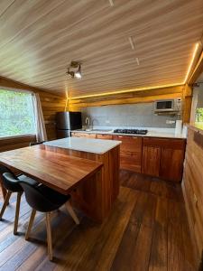 a kitchen with a wooden table and a wooden floor at Las cabañas del Francés in Alto Boquete