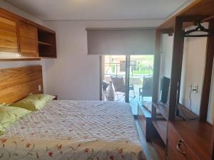 a bedroom with a bed and a flat screen tv at Apto Solluar Flecheiras Trairi in Trairi