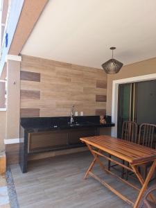 a kitchen with a wooden wall with a table at Apto Solluar Flecheiras Trairi in Trairi