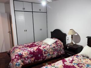 a bedroom with two beds and white cabinets at Peatonal Sarmiento in Mendoza