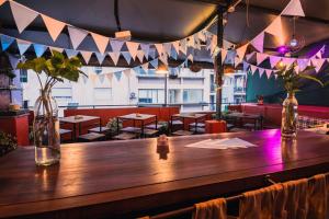 a wooden bar in a restaurant with tables and chairs at Hostel & Spa Mediterránea in Córdoba +82 photos