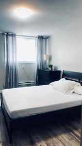a large bed in a bedroom with a window at Wasaga Daze - Unit B in Wasaga Beach