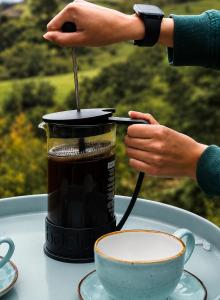 a person stirring a cup of coffee with a spoon at Hichata Breakfast Included in La Calera
