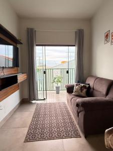 a living room with a couch and a sliding glass door at Apartamento com 2 quartos próximo do centro in Sinop